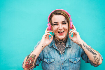 Tattoo girl listening music with headphones