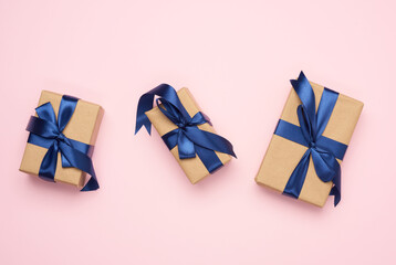rectangular box wrapped in brown paper and tied with a blue silk ribbon with a bow