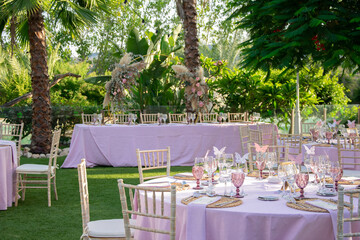 bridal table and table setting of a wedding, marriage or celebration with decoration and pink details in the garden