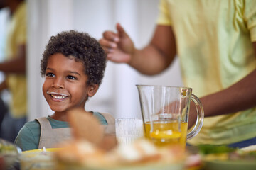 little african boy smiling, having breakfast with milk moustache, making funny face