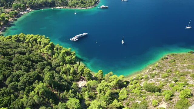 Aerial drone video of beautiful paradise bay and secluded beaches of Skinos covered in pine trees in beautiful Ionian island of Ithaki or Ithaca, Greece