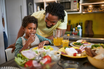 Afro-American male child eating in kitchen