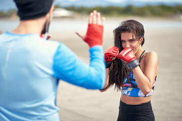 Young female boxer and her coach having a training