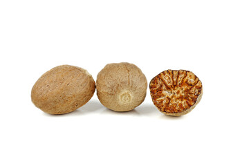 Grated half and whole nutmegs isolated on a white background closeup