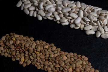 Flat lay composition with different types of grains and cereals on black background