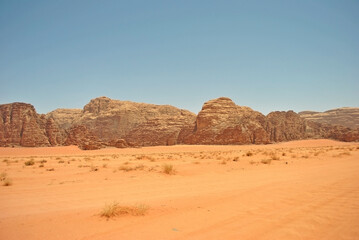 Fototapeta na wymiar Ancient sandstone rocks and orange sand of the Wadi Rum desert