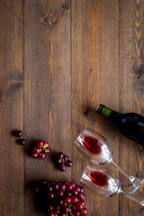 Red wine with grape - in glasses and bottle - on wooden desk top view copy space