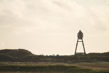 Naklejka premium The beacon on Amelend, A cape or sea cape is a beacon for shipping and is a striking landmark in the landscape. on the beautiful Oerd, protected nature area on Ameland, the Netherlands