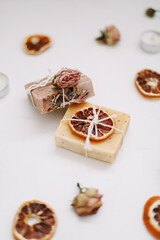 Natural soap with dried slices of oranges on a white background. Handmade soap and ingredients. Flat lay. Space for text, top view