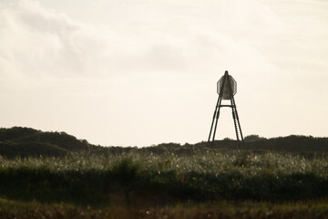 Naklejka premium The beacon on Amelend, A cape or sea cape is a beacon for shipping and is a striking landmark in the landscape. on the beautiful Oerd, protected nature area on Ameland, the Netherlands