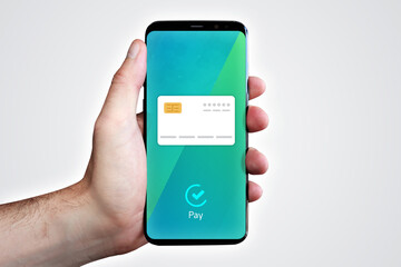 Credit Card Payment. Hand holds phone with icon in the display (blue/turquoise). Gray background
