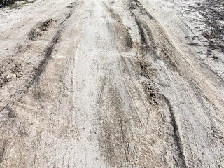 Tyre track and human footprint on sand texture background. Traces of off-road tires. Cracked earth on country road with traces of tires, cars, cracks and dirt. To use as background