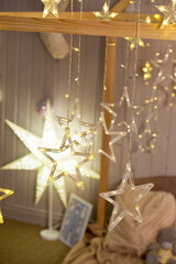 Decoration of garlands of lanterns stars in the child's bedroom. Christmas