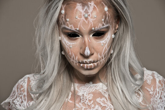 Halloween. Woman in day of the dead mask skull face art. Pearls and black skull make up. Skull bride.