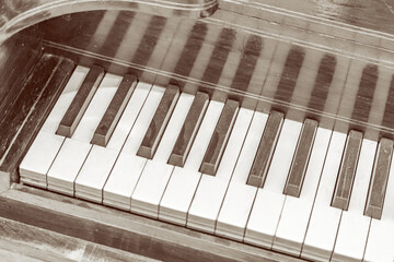 Part of an old antique grand piano with faded keys