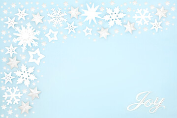 Fototapeta na wymiar Christmas silver joy sign with snowflakes & stars on pastel blue background border. Festive scene for Xmas & New Year holiday season. Flat lay, top view, copy space.