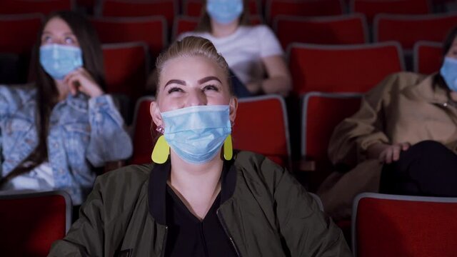 People In Masks Watch Funny Movie. Media. People In Medical Masks Sit In Movie Theater And Laugh While Watching Movie. Opening Of Cinemas During Pandemic Coronavirus