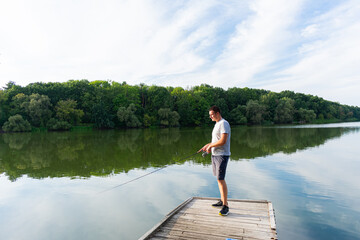 Fototapeta na wymiar Man fishing on the river. Spinning fishing competition