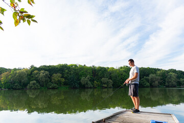 Fototapeta na wymiar Man fishing on the river. Spinning fishing competition