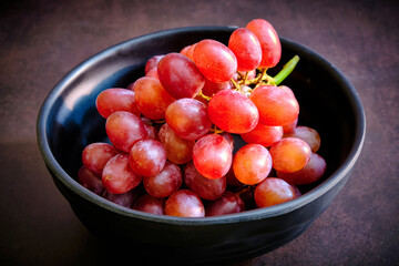 Red delicious fresh grapes on a black bowl. ready to eat