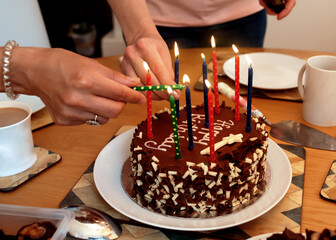 Women lighting a birthday cake candles 