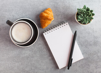 Naklejka na ściany i meble White notebook, coffee and croissant. Blank page of the Notepad to enter text. Copy space. Life style. Flat lay.