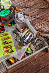 Different fishing tacles with rod and reels on wooden brown background.