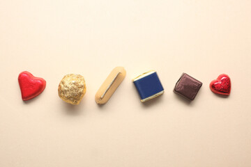 different chocolate candy on beige background with copy space for your tex