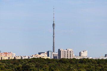 Obraz premium residential district with TV tower and lush green forest on horizon on sunny September day in Moscow city