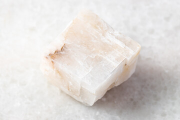 closeup of sample of natural mineral from geological collection - unpolished Calcite rock on white marble background