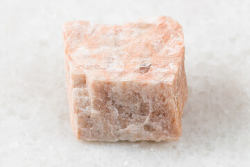 closeup of sample of natural mineral from geological collection - unpolished Feldspar rock on white...