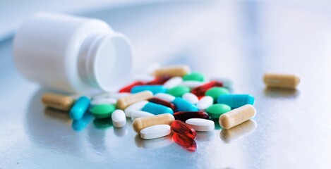 White bottle with different pills, drugs on white background, flat lay. 
Space for text. Top view.