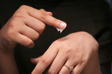 woman applying beauty cream onto skin at home 