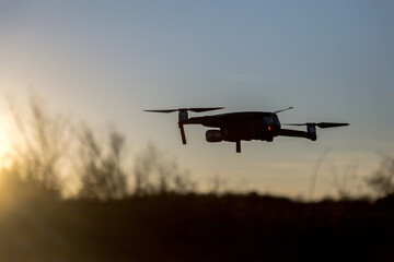 Flying drone on the background of a beautiful sunset sky