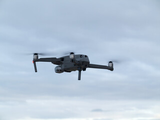 Fototapeta na wymiar Drone with camera flying over blue sky background
