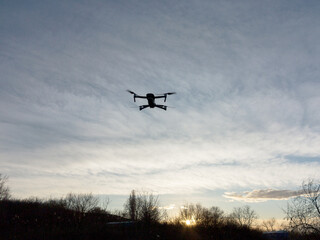 Fototapeta na wymiar Flying drone on the background of a beautiful sunset sky