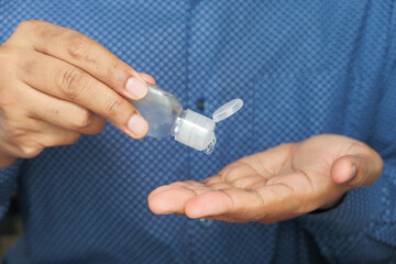 close up of young man hand using sanitizer gel for preventing virus 