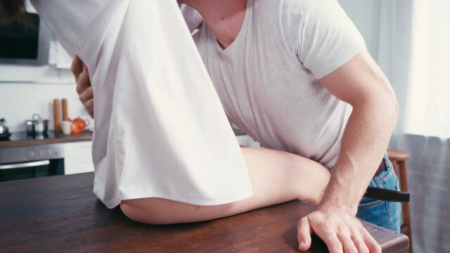 Sexy couple touching each other on kitchen table 