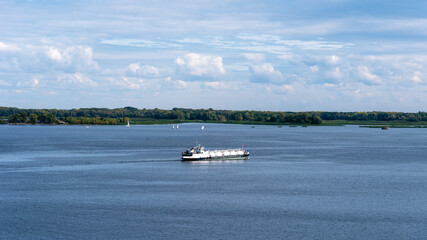 Obraz premium Gas tanker sails along the coast on a sunny day