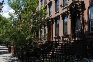 Fototapeta na wymiar Row of Old Brownstone Homes in Bedford-Stuyvesant in Brooklyn of New York City along an Empty Sidewalk
