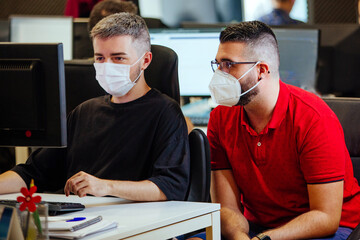 office worker wearing a mask for covid19 or coronavirus. Is in front of a computer