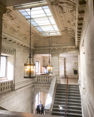 Hall or hallway in public building with marble columns and archs or archways, old lamps and ceiling...