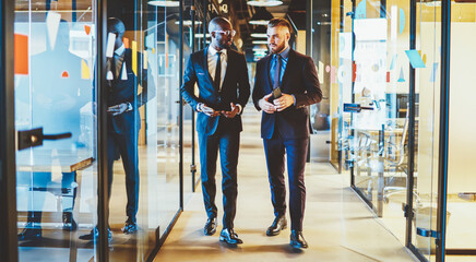Fototapeta premium African American owner of financial company discussing business project and cooperation with experienced executive director dressed in formal wear, confident multicultural entrepreneurs talking