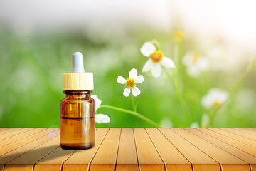 Oil bottle on Wooden floor with grass and wildflowers background