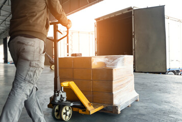 Workers Using Hand Pallet Jack Unloading Package Boxes into Shipping Cargo Container. Delivery Shipment Boxes. Trucks Loading at Dock Warehouse. Supplies. Warehouse Shipping Transport and Logistics. - obrazy, fototapety, plakaty