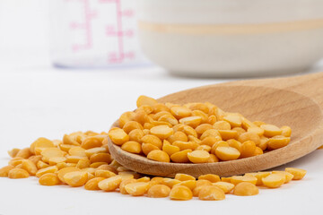 uncooked yellow split peas in a wooden cookng spoon