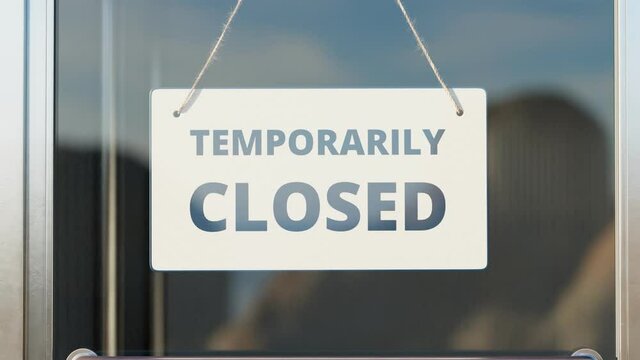Temporarily closed due to COVID-19. Zoom in white close sign on the glass door.