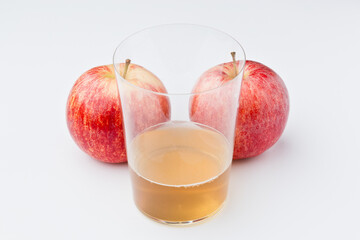 Red apple, with white background. And glass of cider Asturias, Spain