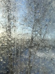 snow melts on the window ice is covered with wet flowing water