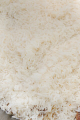 Cooking pilaf in a cauldron on the grill outside in the summer